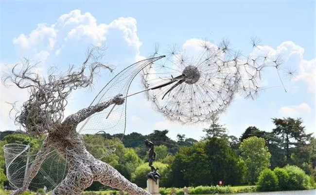 仙女雕塑和跳舞的蒲公英